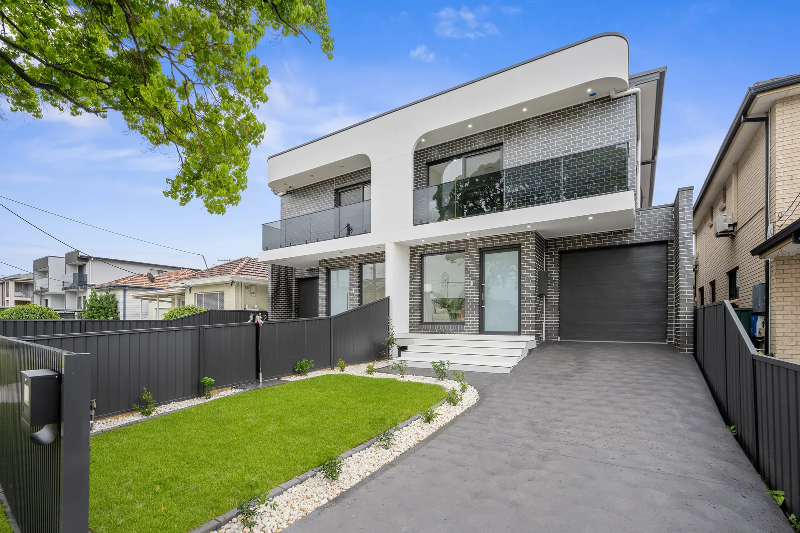 Two-storey white duplex in Sydney with lawn and driveway